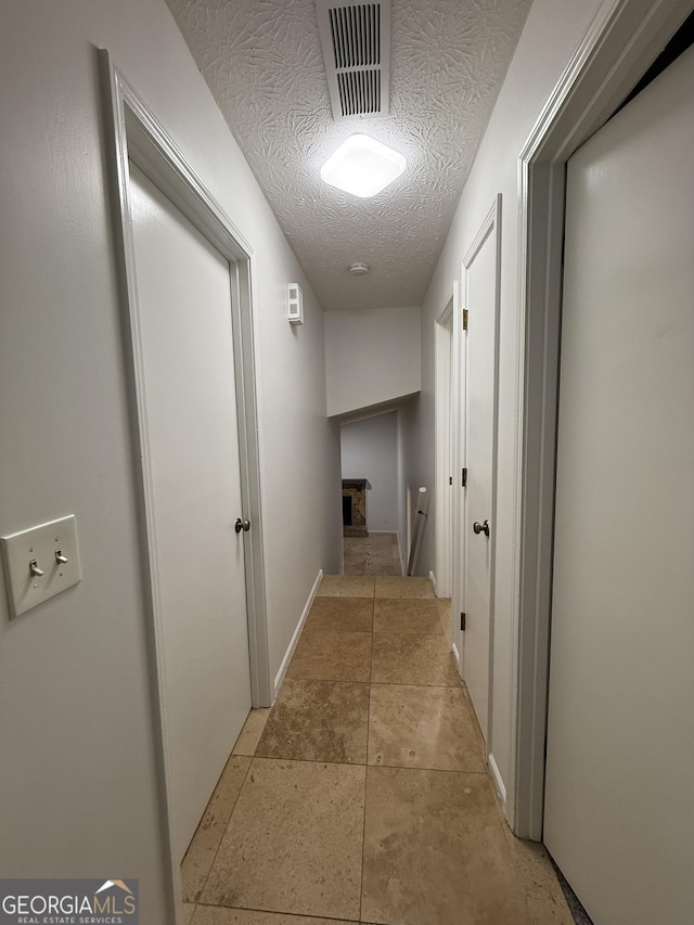 hallway featuring a textured ceiling