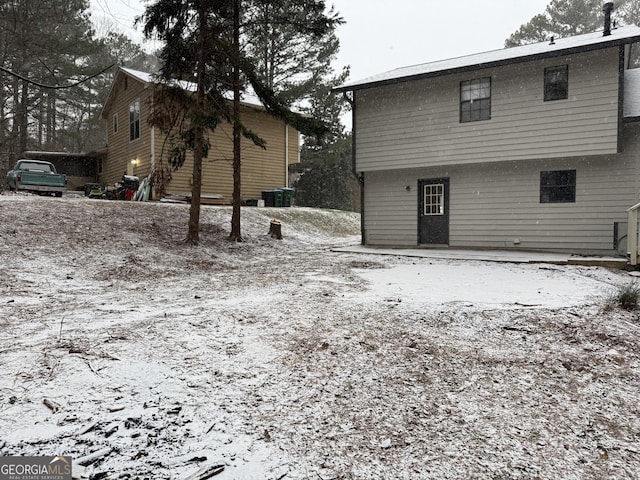 view of snow covered rear of property