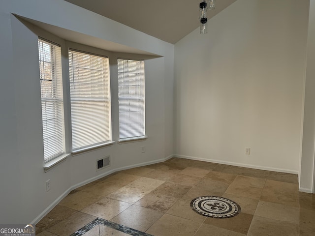 unfurnished room with vaulted ceiling