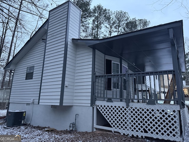 view of snowy exterior with cooling unit