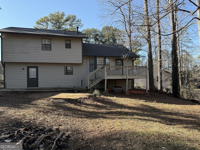 back of house with a deck and a lawn