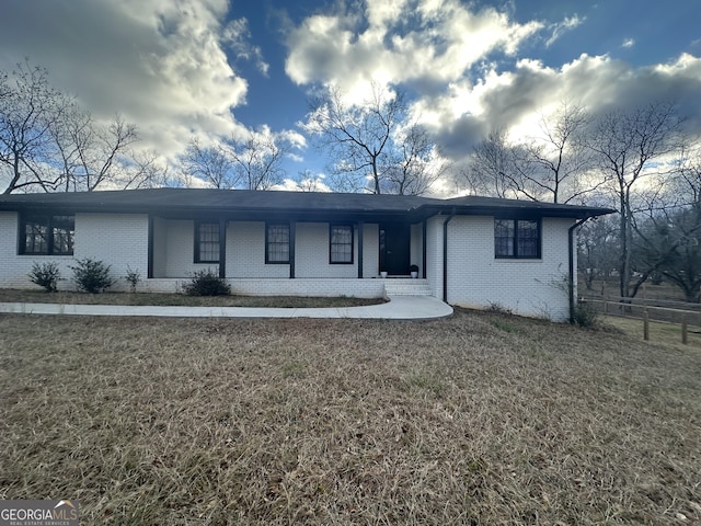 single story home featuring covered porch and a front lawn