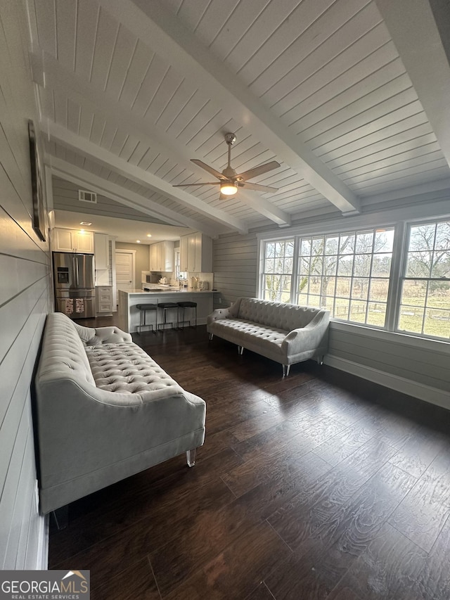 bedroom featuring ceiling fan, stainless steel fridge, dark hardwood / wood-style flooring, and vaulted ceiling with beams