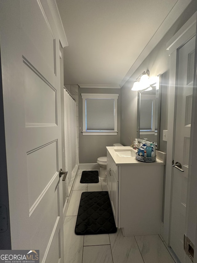 bathroom with vanity, toilet, ornamental molding, and curtained shower