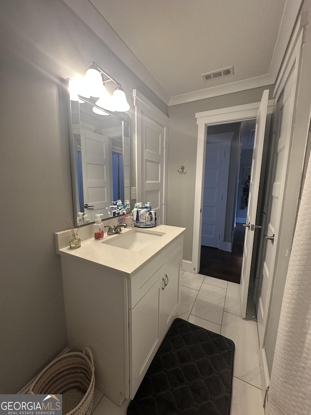 bathroom with vanity, ornamental molding, and tile patterned flooring