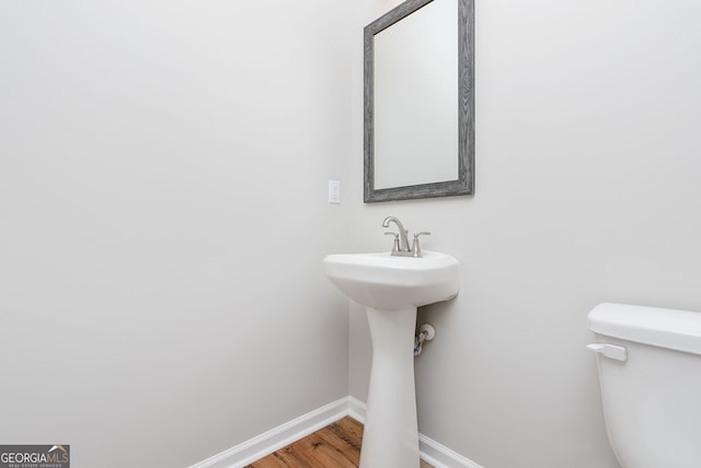 bathroom with toilet and hardwood / wood-style floors