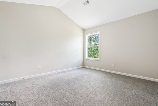 carpeted spare room with lofted ceiling