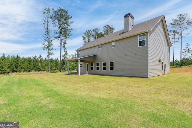 back of property with a patio area and a yard