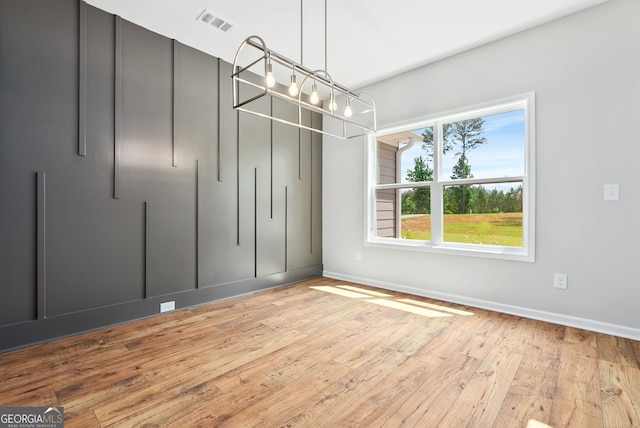 spacious closet featuring a notable chandelier and light hardwood / wood-style floors