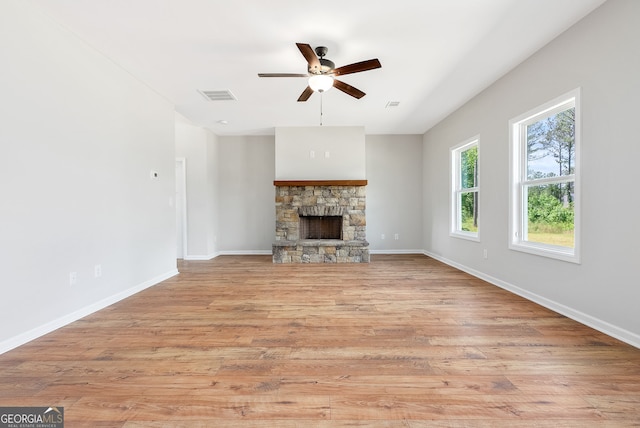 unfurnished living room with ceiling fan, light hardwood / wood-style floors, and a fireplace