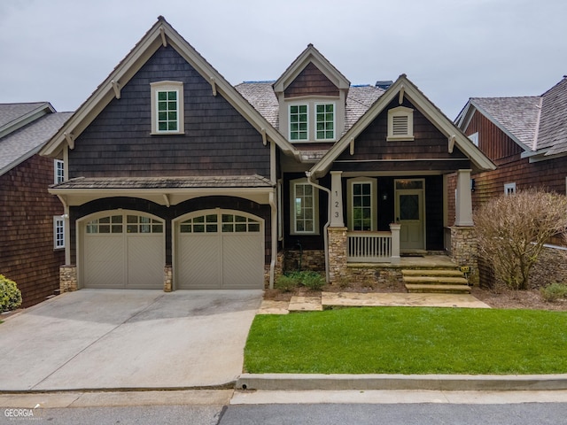 craftsman-style house with a porch, a garage, and a front lawn