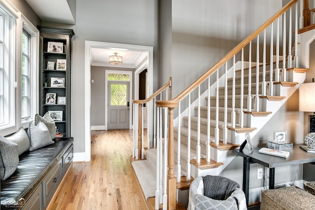 foyer featuring ornamental molding and light hardwood / wood-style floors