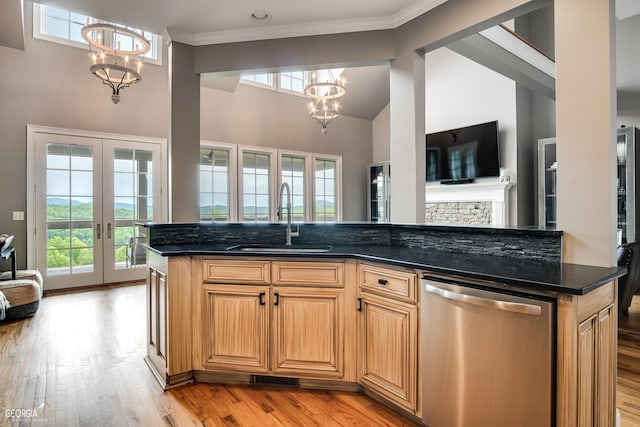 kitchen with sink, dishwasher, a chandelier, and dark stone counters