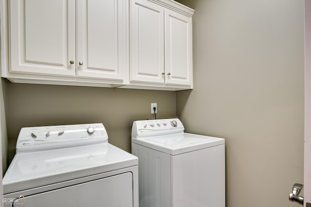 clothes washing area with cabinets and independent washer and dryer