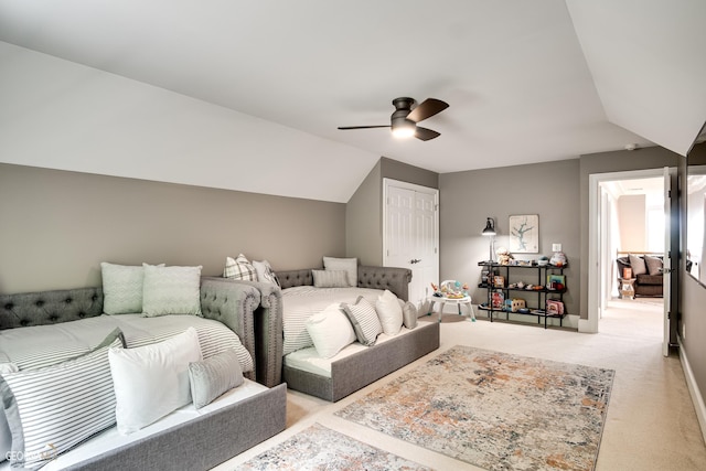 carpeted bedroom with a closet, ceiling fan, and vaulted ceiling