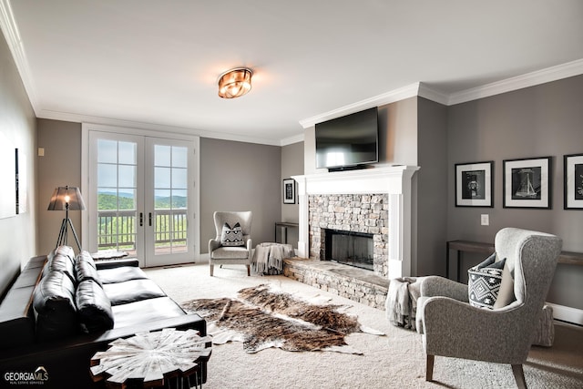 living room featuring a fireplace, ornamental molding, carpet flooring, and french doors