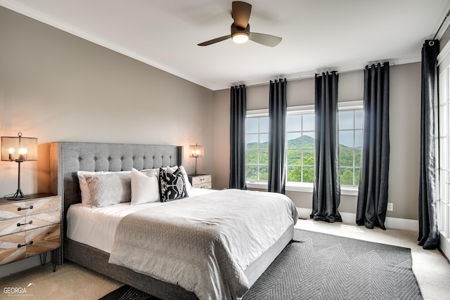 carpeted bedroom featuring ceiling fan and ornamental molding