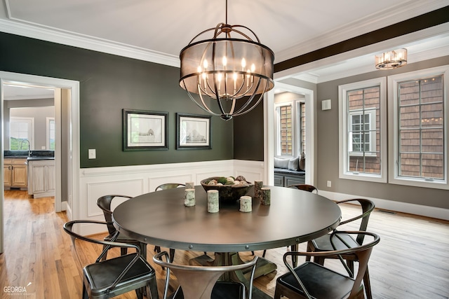 dining room featuring an inviting chandelier, a wealth of natural light, and ornamental molding