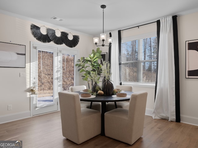 dining room with ornamental molding, light hardwood / wood-style floors, and a wealth of natural light