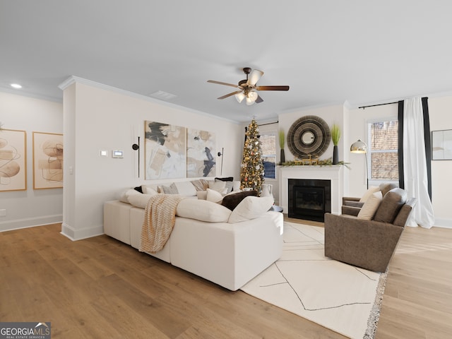 living room featuring crown molding, ceiling fan, and hardwood / wood-style flooring