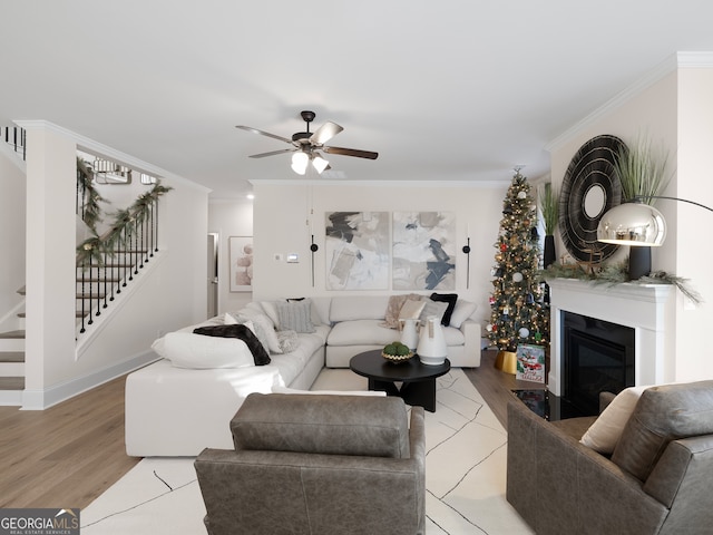 living room featuring crown molding, ceiling fan, and hardwood / wood-style flooring