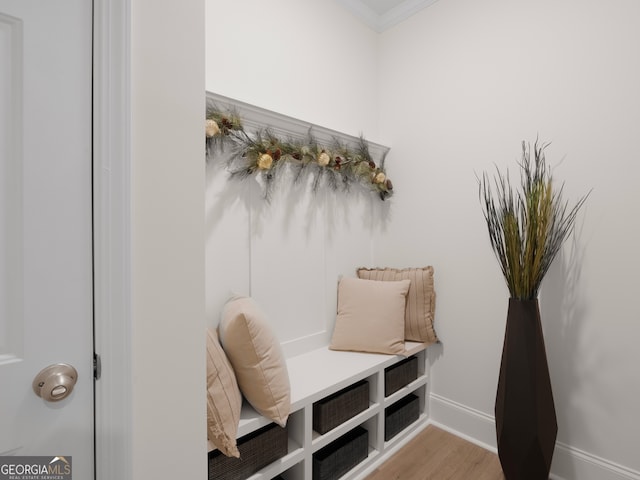 mudroom with ornamental molding and light hardwood / wood-style flooring