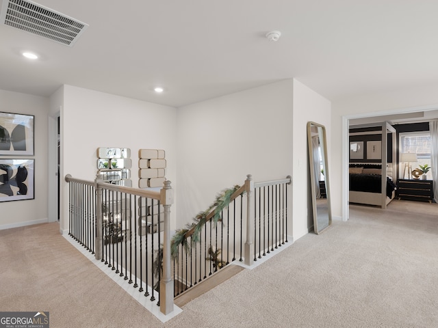 hallway featuring light colored carpet