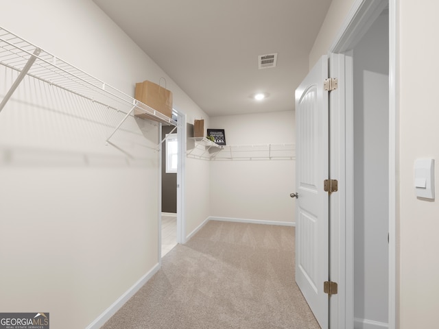 spacious closet featuring light carpet