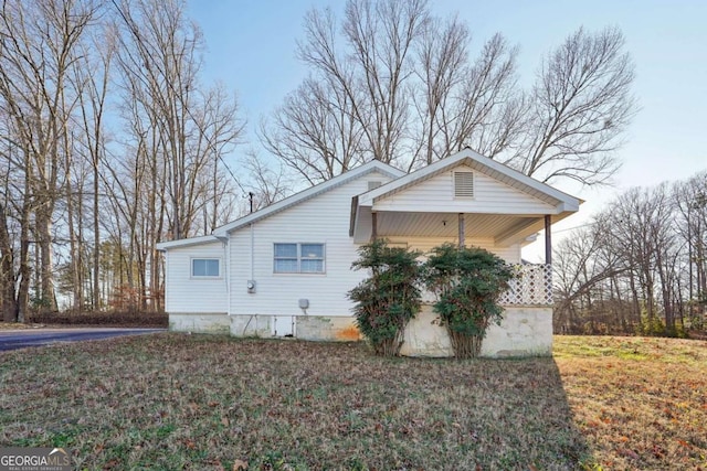 view of home's exterior with covered porch and a yard