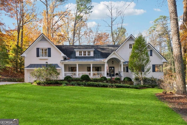 view of front of property with a garage, a front yard, and covered porch