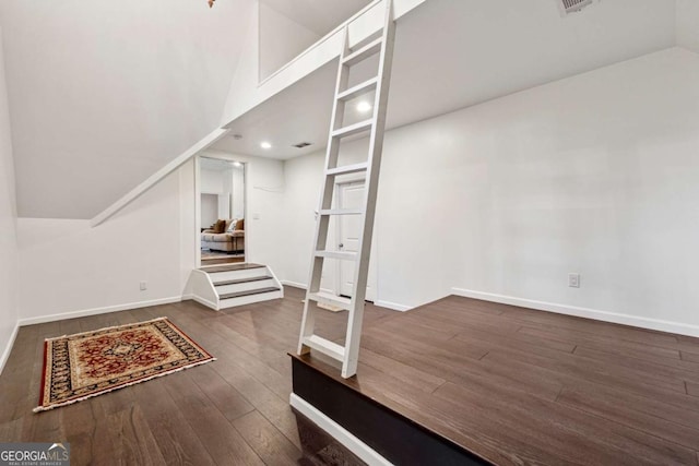 interior space featuring lofted ceiling and dark hardwood / wood-style flooring