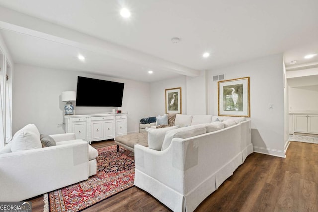 living room featuring beamed ceiling and dark hardwood / wood-style flooring