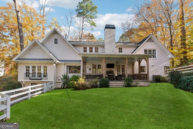 back of property with a lawn and a porch