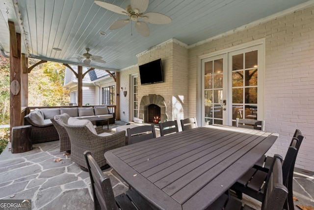 view of patio / terrace featuring an outdoor living space with a fireplace and ceiling fan