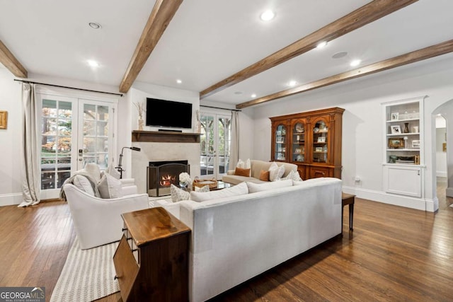 living room with dark hardwood / wood-style flooring, built in features, french doors, and beamed ceiling