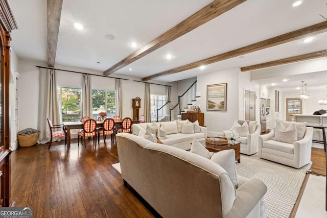 living room featuring beamed ceiling, wood-type flooring, and a notable chandelier