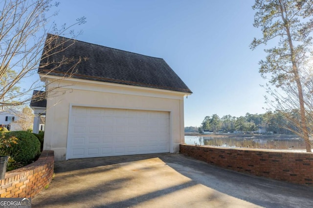 view of home's exterior with a water view and a garage