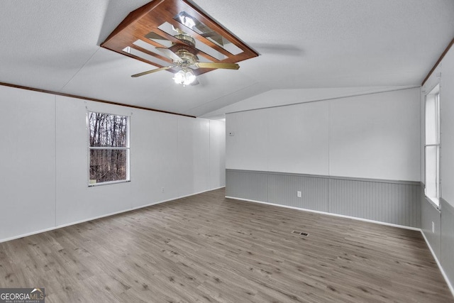 interior space featuring ceiling fan, a wealth of natural light, lofted ceiling, and hardwood / wood-style floors