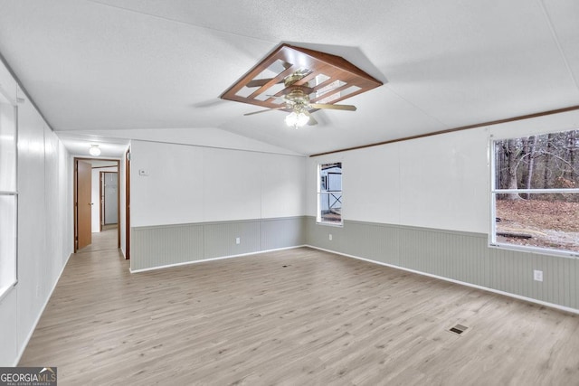 spare room with ceiling fan, light hardwood / wood-style floors, and lofted ceiling