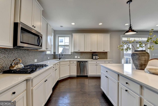 kitchen with sink, white cabinetry, appliances with stainless steel finishes, and pendant lighting