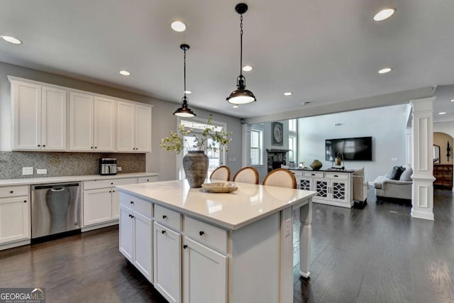 kitchen with decorative columns, white cabinets, decorative light fixtures, and stainless steel dishwasher