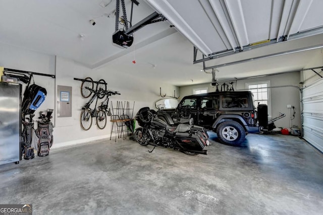 garage with a garage door opener and electric panel