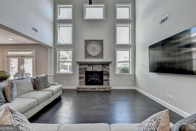 living room with a fireplace, a high ceiling, and a wealth of natural light