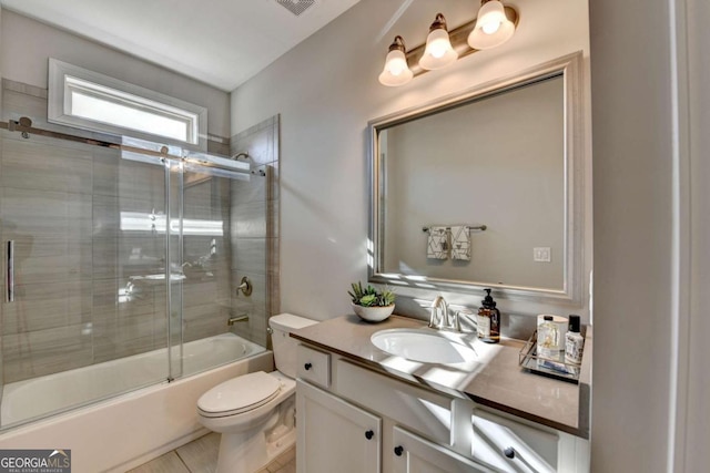 full bathroom featuring vanity, toilet, combined bath / shower with glass door, and tile patterned flooring