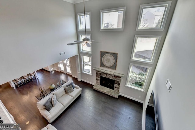 living room featuring ceiling fan, a high ceiling, a healthy amount of sunlight, and a fireplace