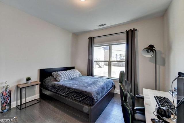 bedroom with dark hardwood / wood-style flooring