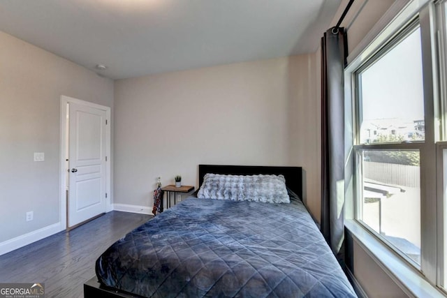 bedroom with multiple windows and dark hardwood / wood-style flooring