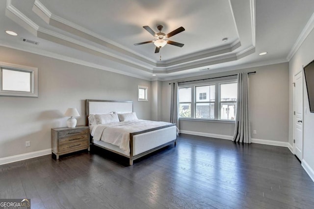 bedroom with crown molding, dark wood-type flooring, ceiling fan, and a raised ceiling