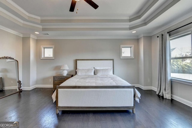 bedroom featuring multiple windows, a tray ceiling, ceiling fan, and ornamental molding