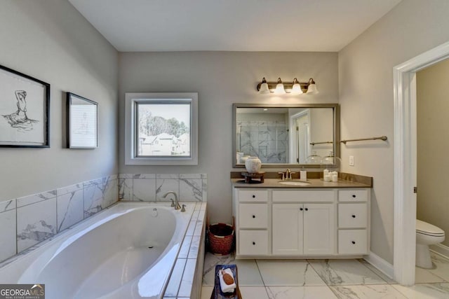 bathroom featuring vanity, toilet, and tiled tub